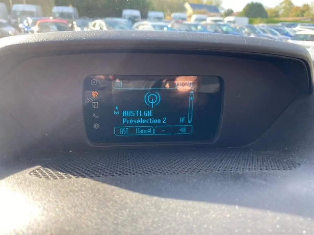 Écran central du tableau de bord du Ford Transit Fourgon L3H2 2015 affichant une station radio en mode manuel.