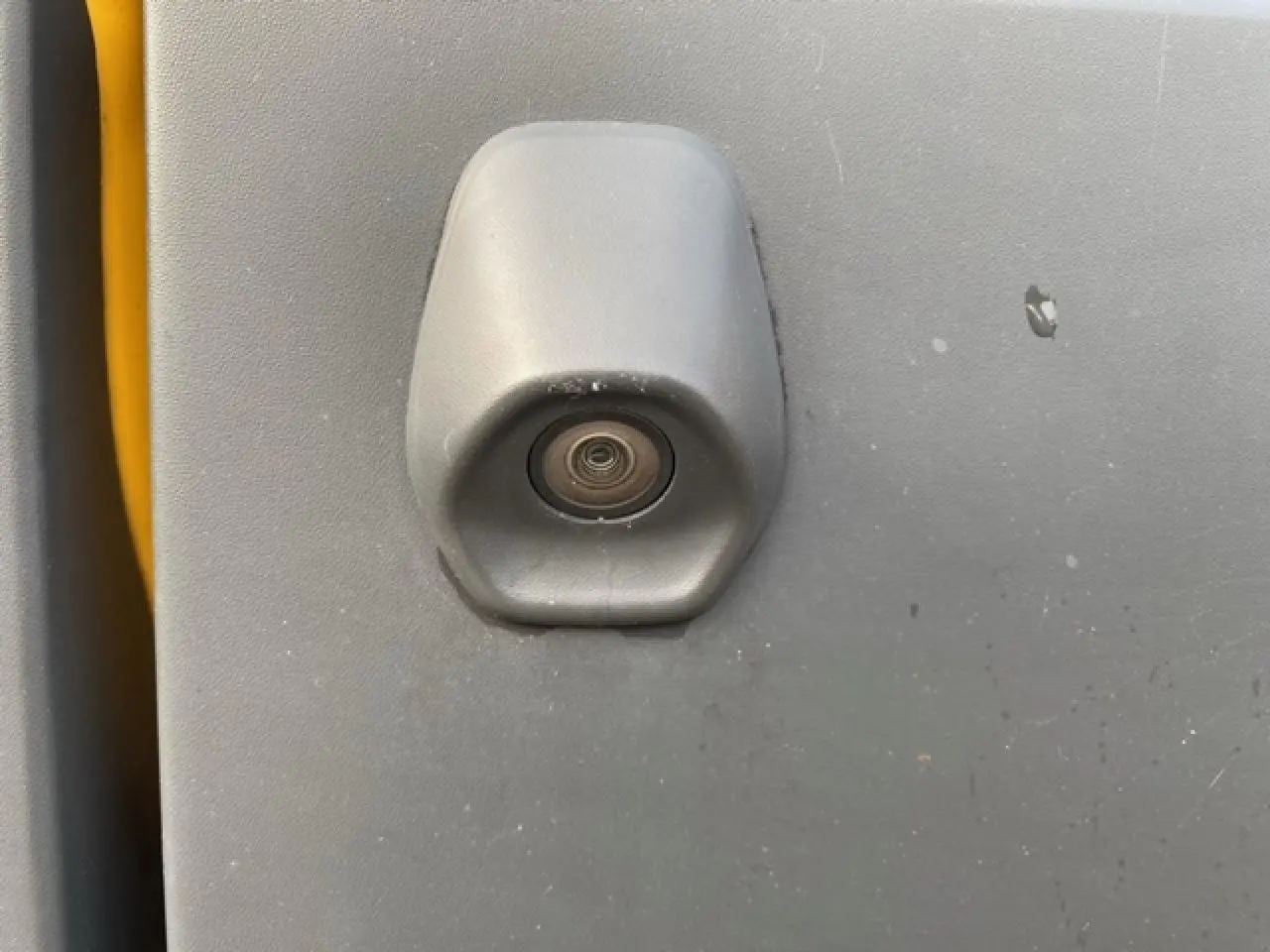 Gros plan sur la caméra de recul intégrée à la porte arrière grise du Ford Transit Fourgon orange L3H2 2015.