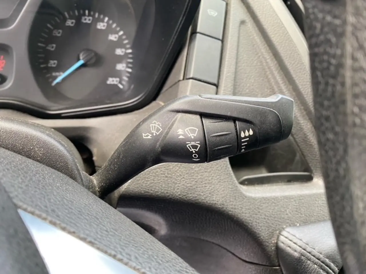 Gros plan sur la manette de commande des essuie-glaces du tableau de bord d'un Ford Transit Fourgon 2015.