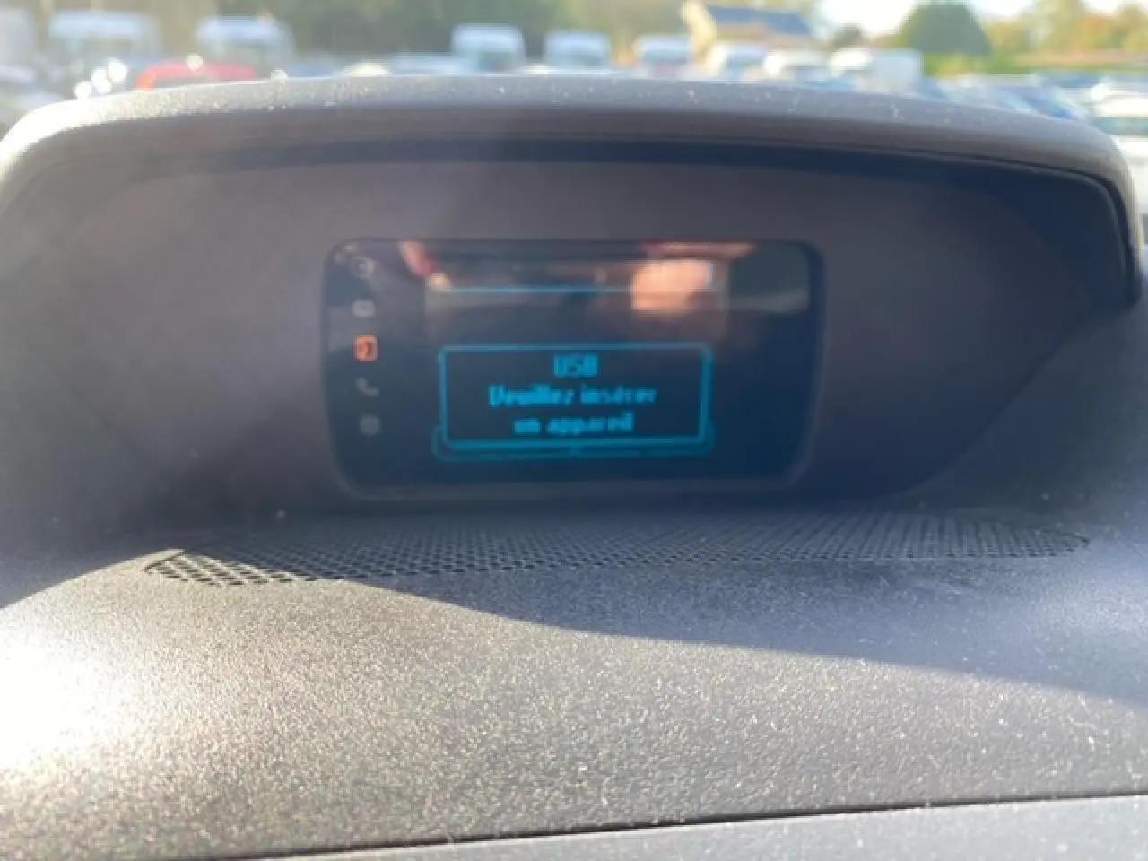 Écran central du tableau de bord du Ford Transit Fourgon orange 2015 affichant un message USB, vue intérieure rapprochée.