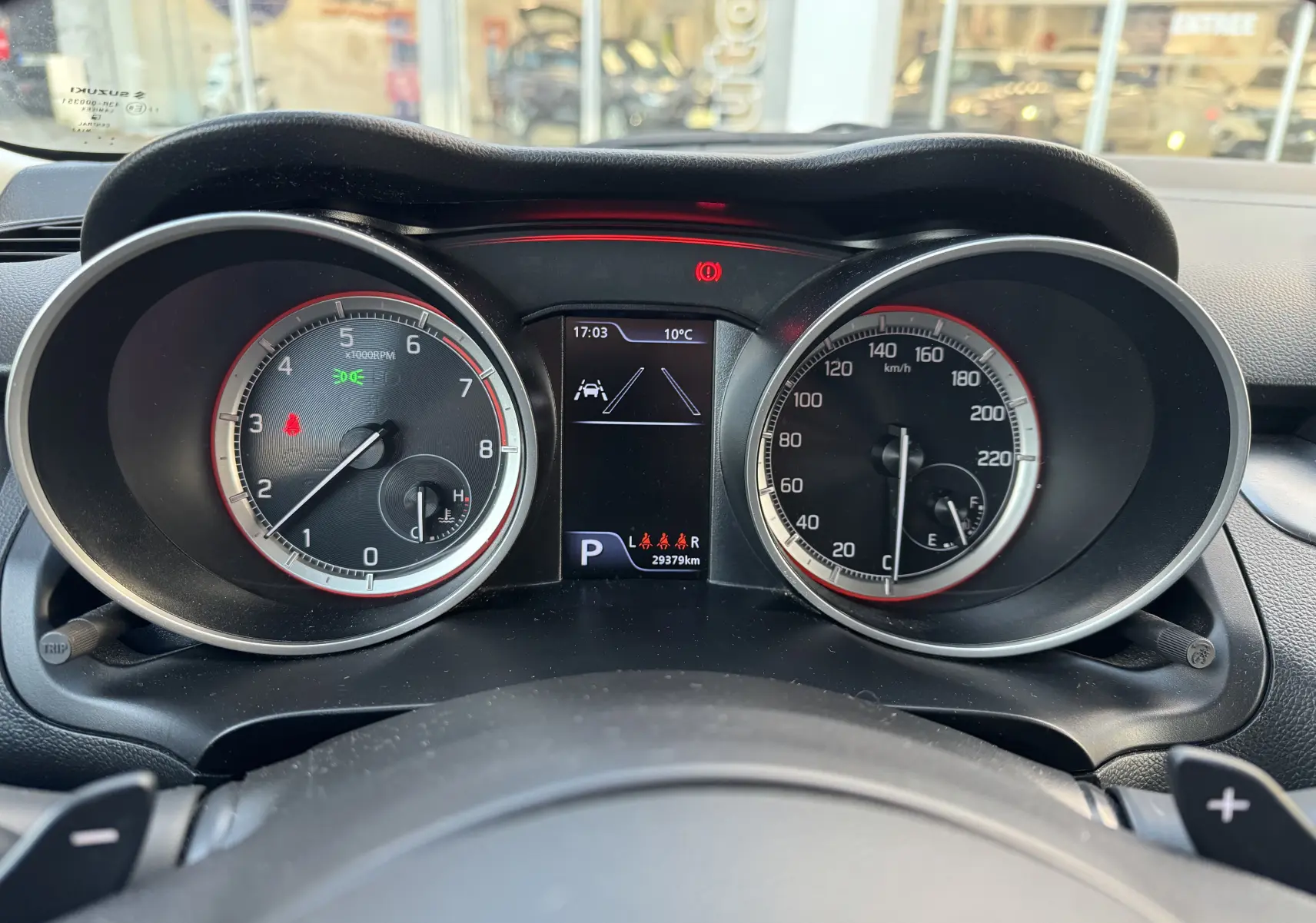 Vue rapprochée du tableau de bord de la Suzuki Swift 1.2 Pack Auto 2023, affichant compte-tours et vitesse.