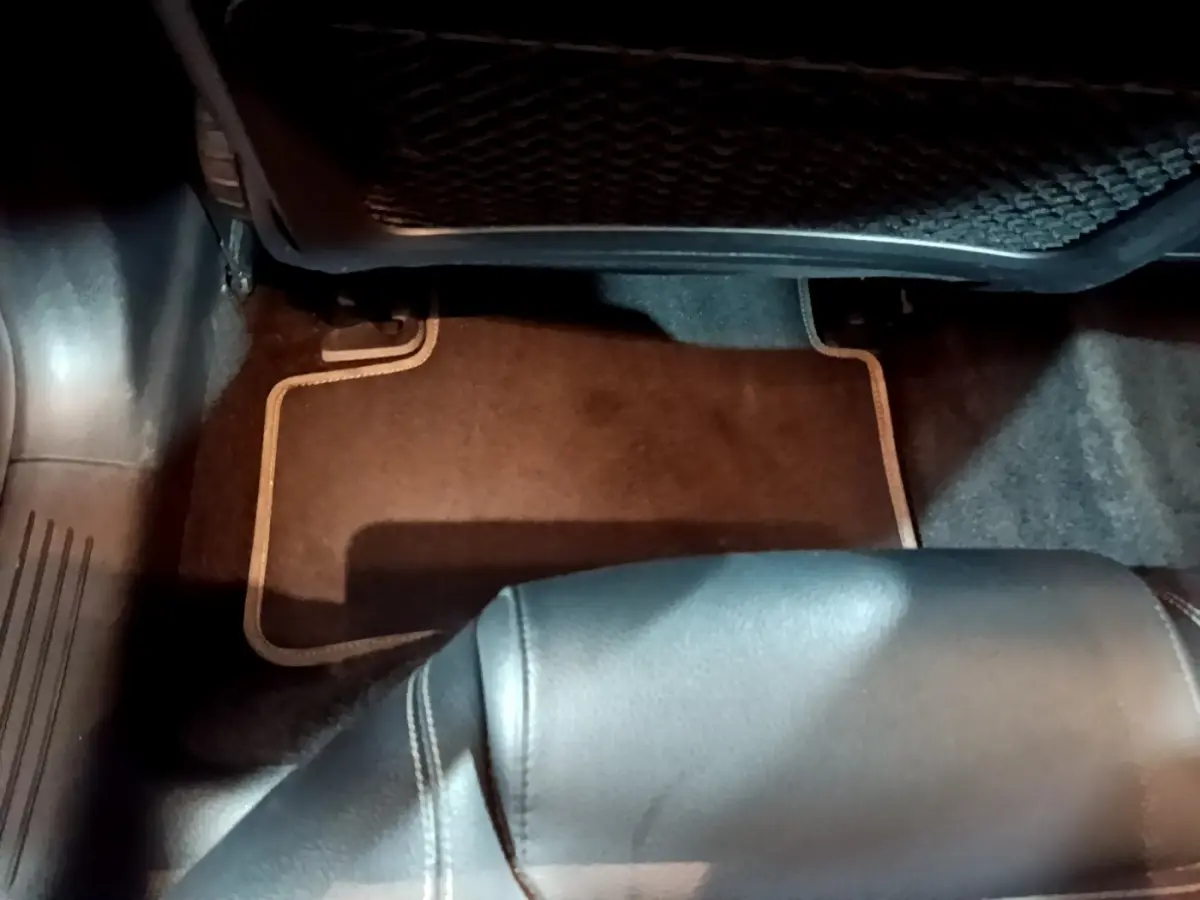 Vue intérieure du plancher côté passager arrière d'une Mercedes CLA 180 d Business Line gris clair avec tapis de sol noir.