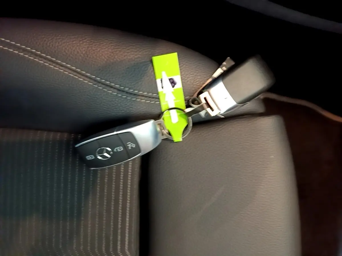 Gros plan sur clé Mercedes posée sur siège en cuir noir avec surpiqûres blanches, intérieur CLA 180 d Business Line.