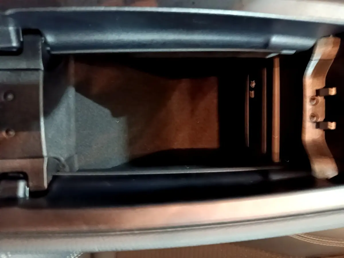 Vue rapprochée de l'accoudoir central ouvert d'une Mercedes CLA 180 d Business Line gris clair, intérieur noir.