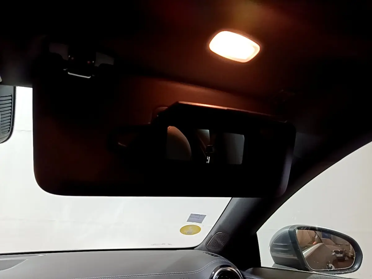 Vue intérieure côté conducteur du rétroviseur et tableau de bord d’une Mercedes CLA 180 d Business Line gris clair 2021.