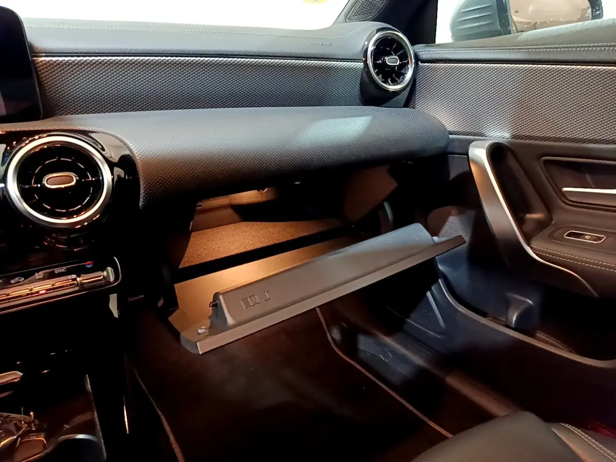 Intérieur de la Mercedes CLA 180 d Business Line 2021, vue côté passager avec boîte à gants ouverte et tableau de bord noir.
