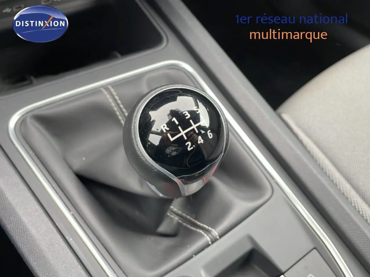 Gros plan sur le levier de vitesse manuel noir de la SEAT LEON 2.0 TDI 115CH STYLE XL, avec sellerie tissu grise visible.