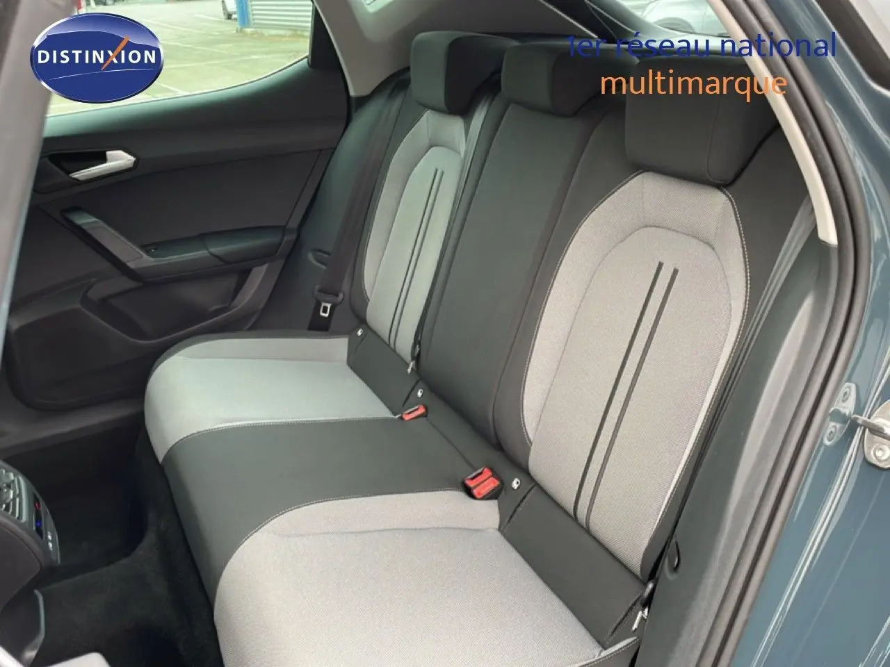 Vue intérieure côté arrière droit montrant la banquette bicolore gris clair et noir du SEAT LEON 2025 gris magnétique métal.
