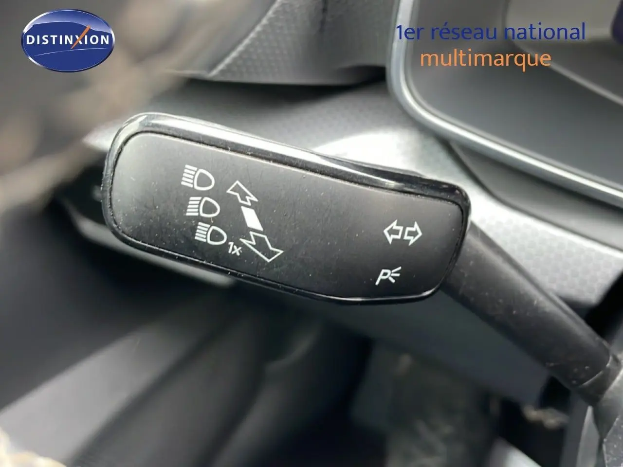 Gros plan sur la manette de clignotants intérieure du SEAT LEON 2025 gris magnétique, avec pictogrammes blancs visibles.
