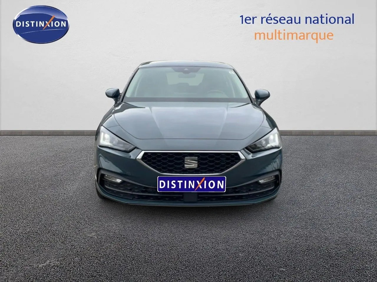 Vue frontale d'une SEAT Leon 2025 gris magnétique métal avec calandre hexagonale et phares LED distinctifs.
