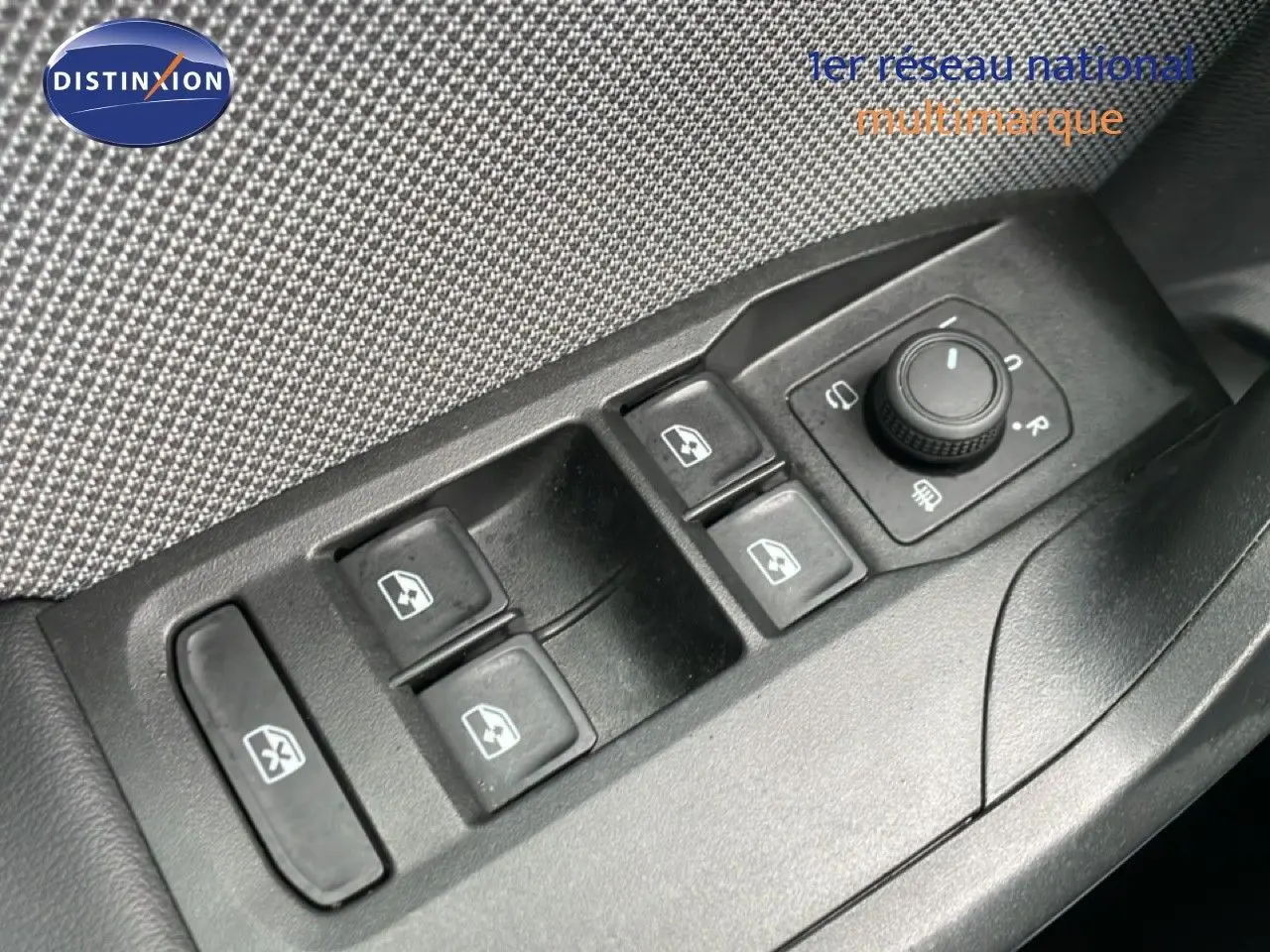 Gros plan sur les commandes des vitres électriques et rétroviseurs côté conducteur d'une SEAT Leon gris magnétique 2025.
