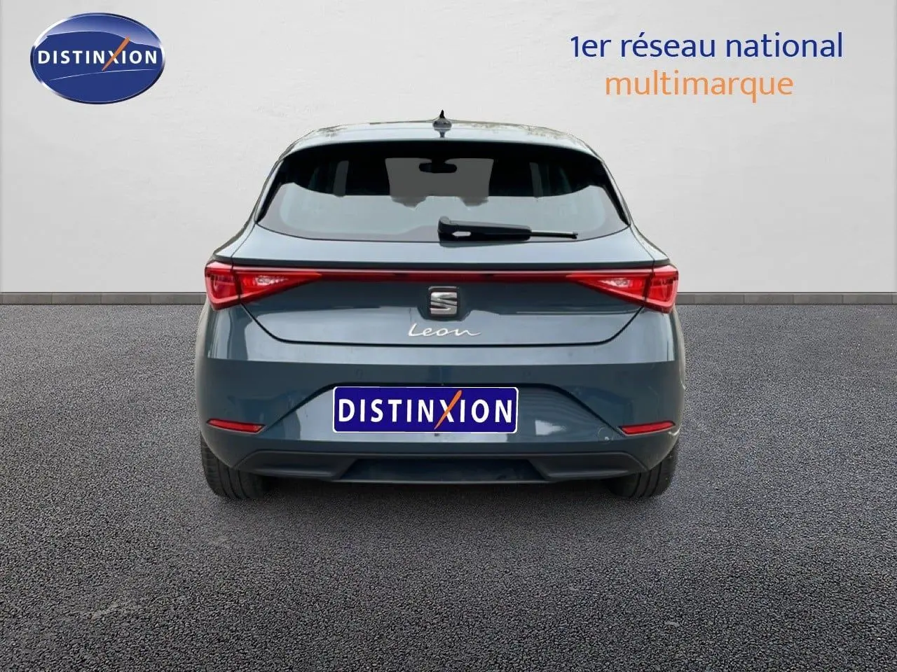 Vue arrière d'une SEAT Leon gris magnétique métal 2025, avec feux arrière LED et logo central visible.