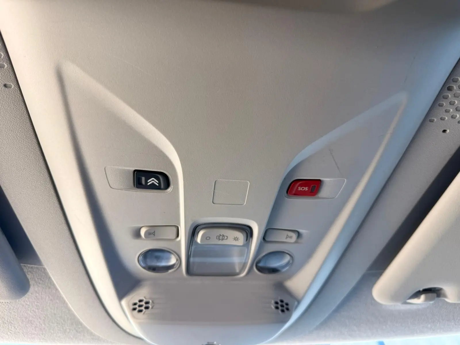 Vue en gros plan du plafonnier gris clair avec boutons de commande et alerte SOS dans un Citroën Berlingo blanc 2020.