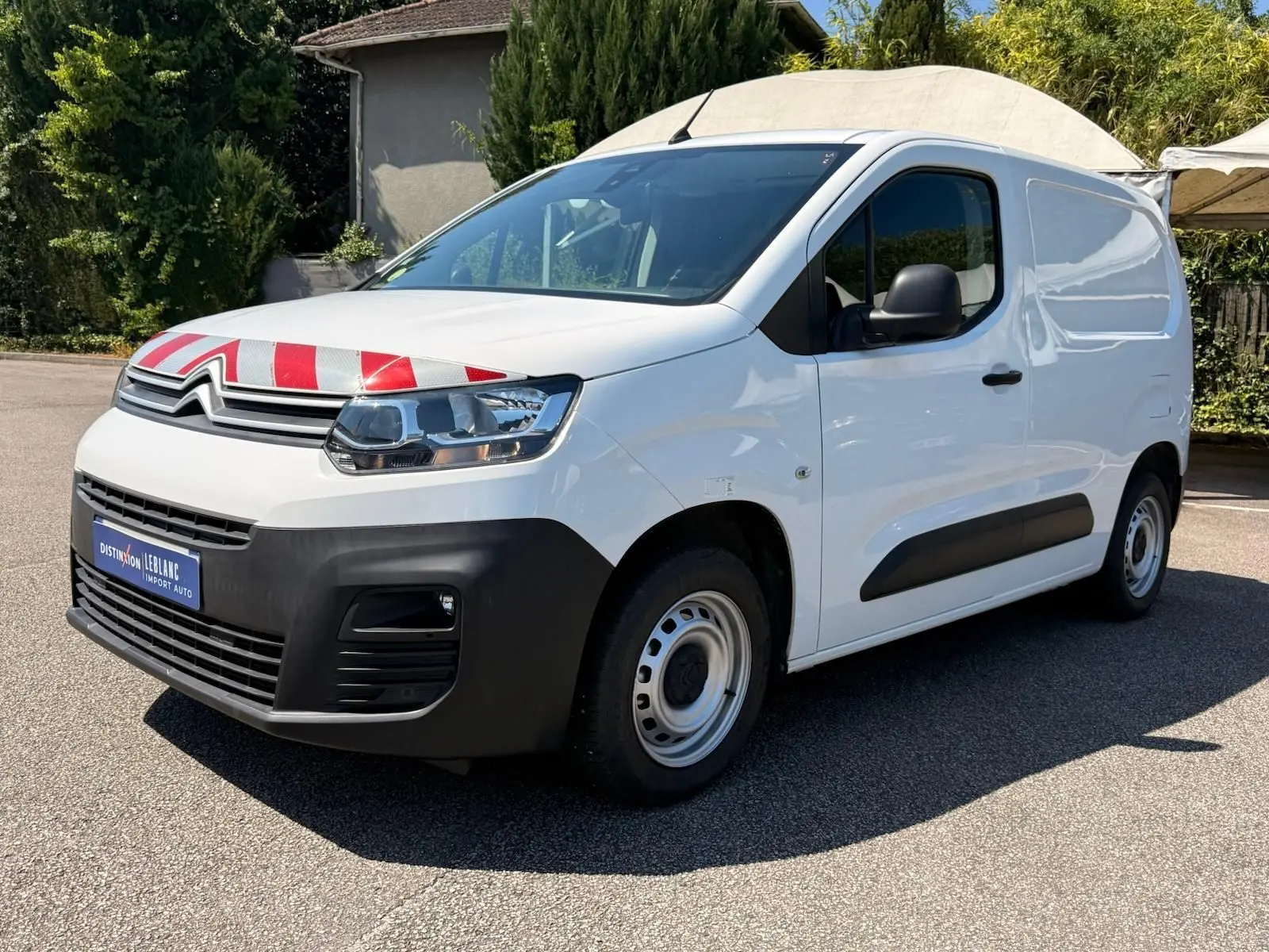 Vue 3/4 avant droit du Citroën Berlingo Van blanc avec marquage rouge sur le capot et pare-chocs noir.