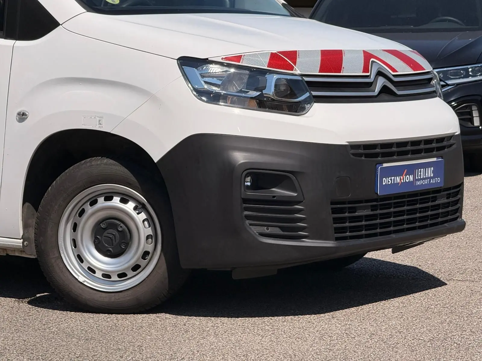 Vue avant droite d'un Citroën Berlingo blanc 2020 avec pare-chocs noir et jante acier simple.