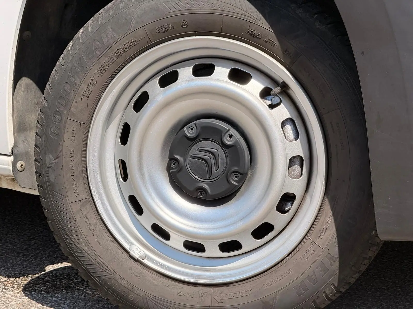 Gros plan sur la roue avant gauche du Citroën Berlingo blanc, jante acier avec logo Citroën au centre.