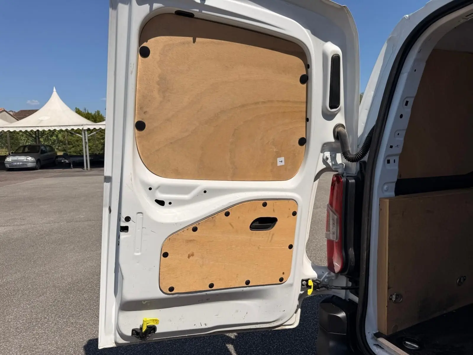 Vue arrière gauche du Citroën Berlingo Van blanc 2020 avec porte ouverte montrant le revêtement bois intérieur.