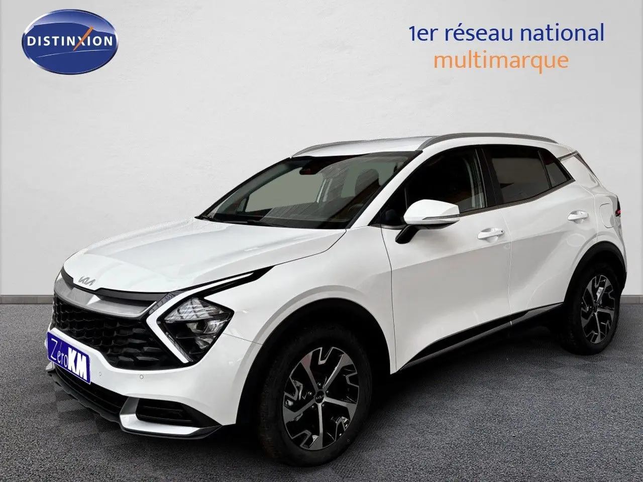 KIA SPORTAGE blanc nacré métal en 3/4 avant droit, avec jantes noires et détails de calandre distinctifs.