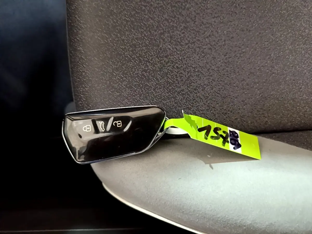 Télécommande noire de Volkswagen ID.3 77 kWh Pro S posée sur un siège gris, vue rapprochée intérieure.