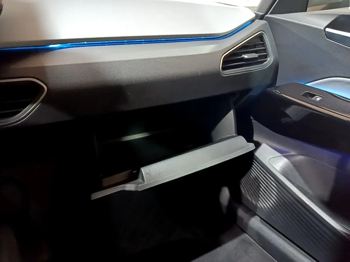 Intérieur côté passager du Volkswagen ID.3 77 kWh Pro S 2022, boîte à gants ouverte, ambiance lumineuse bleue.