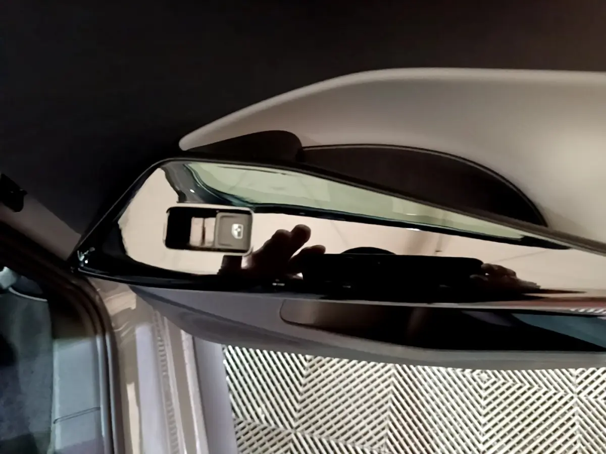 Gros plan sur le rétroviseur extérieur droit noir brillant du Volkswagen ID.3 gris foncé, intérieur partiel visible.