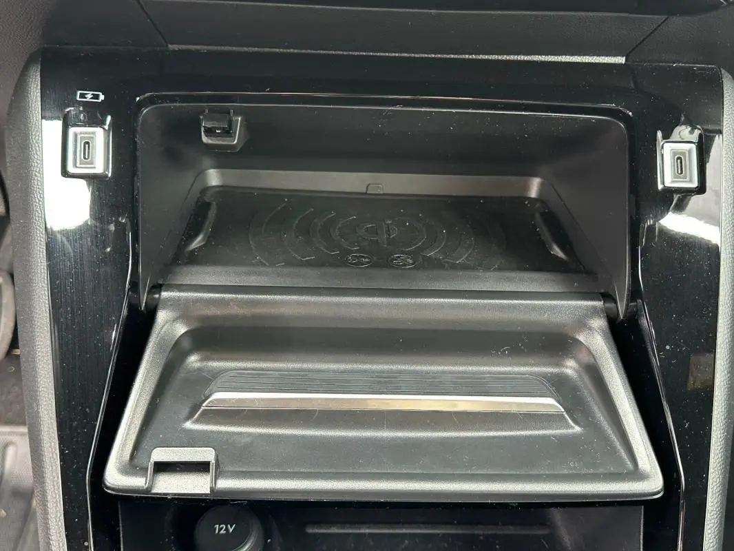 Vue rapprochée de la console centrale noire du Peugeot 2008 Hybrid 136 e-DCS6 Allure avec compartiment ouvert et ports USB visibles.