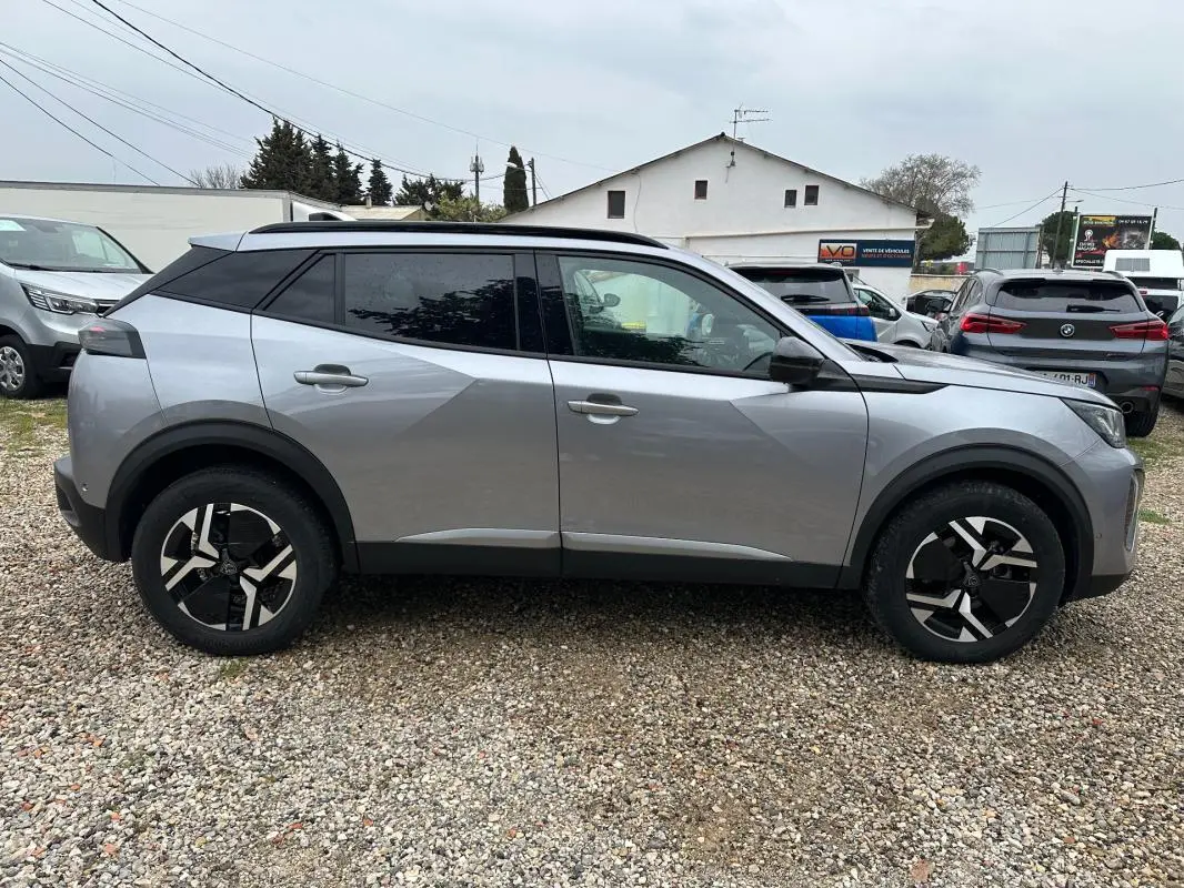 Peugeot 2008 Hybrid gris vue de profil côté gauche, avec barres de toit et jantes alliage 17 pouces.