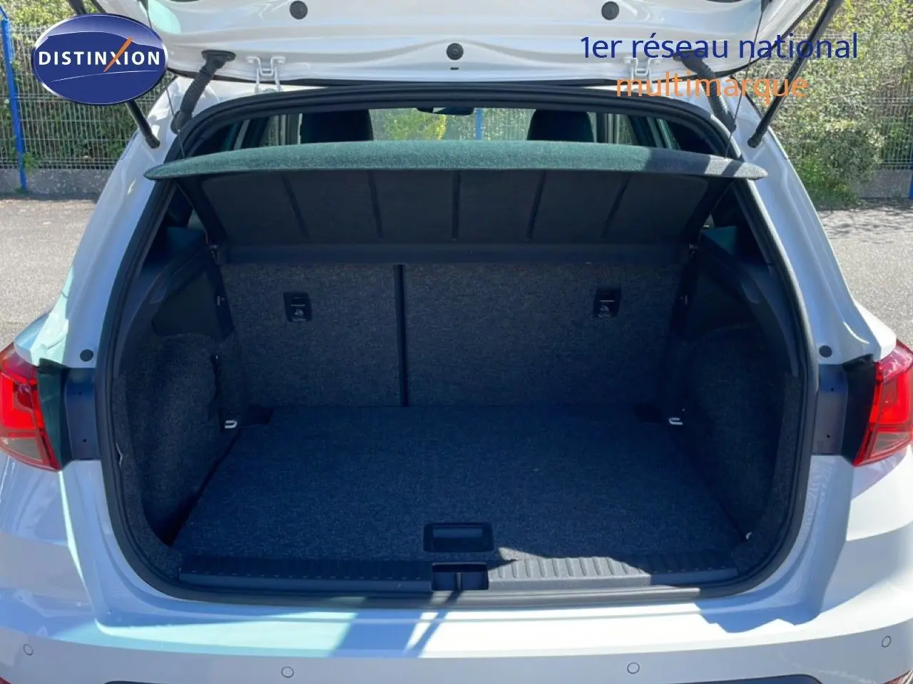 Coffre ouvert vu de l'arrière d'un SEAT Arona blanc avec toit noir, montrant l'espace de chargement vide.