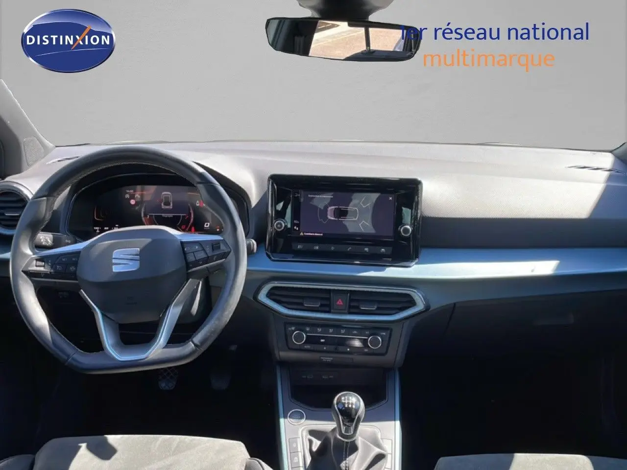 Intérieur avant du SEAT Arona 2025, tableau de bord noir avec écran tactile et volant multifonction.