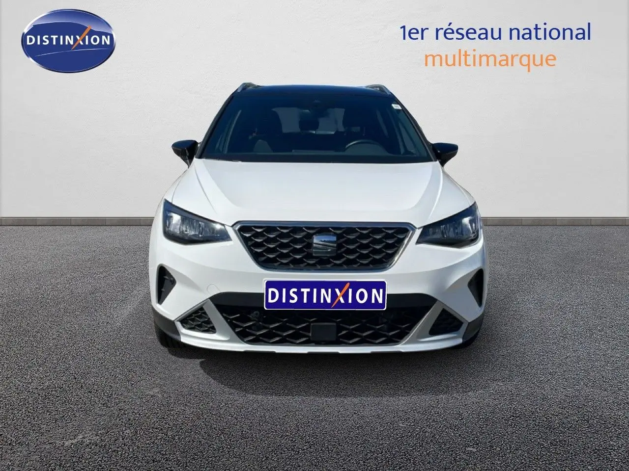 Vue avant du SEAT Arona blanc avec toit noir, mettant en valeur sa calandre distinctive et ses phares LED.