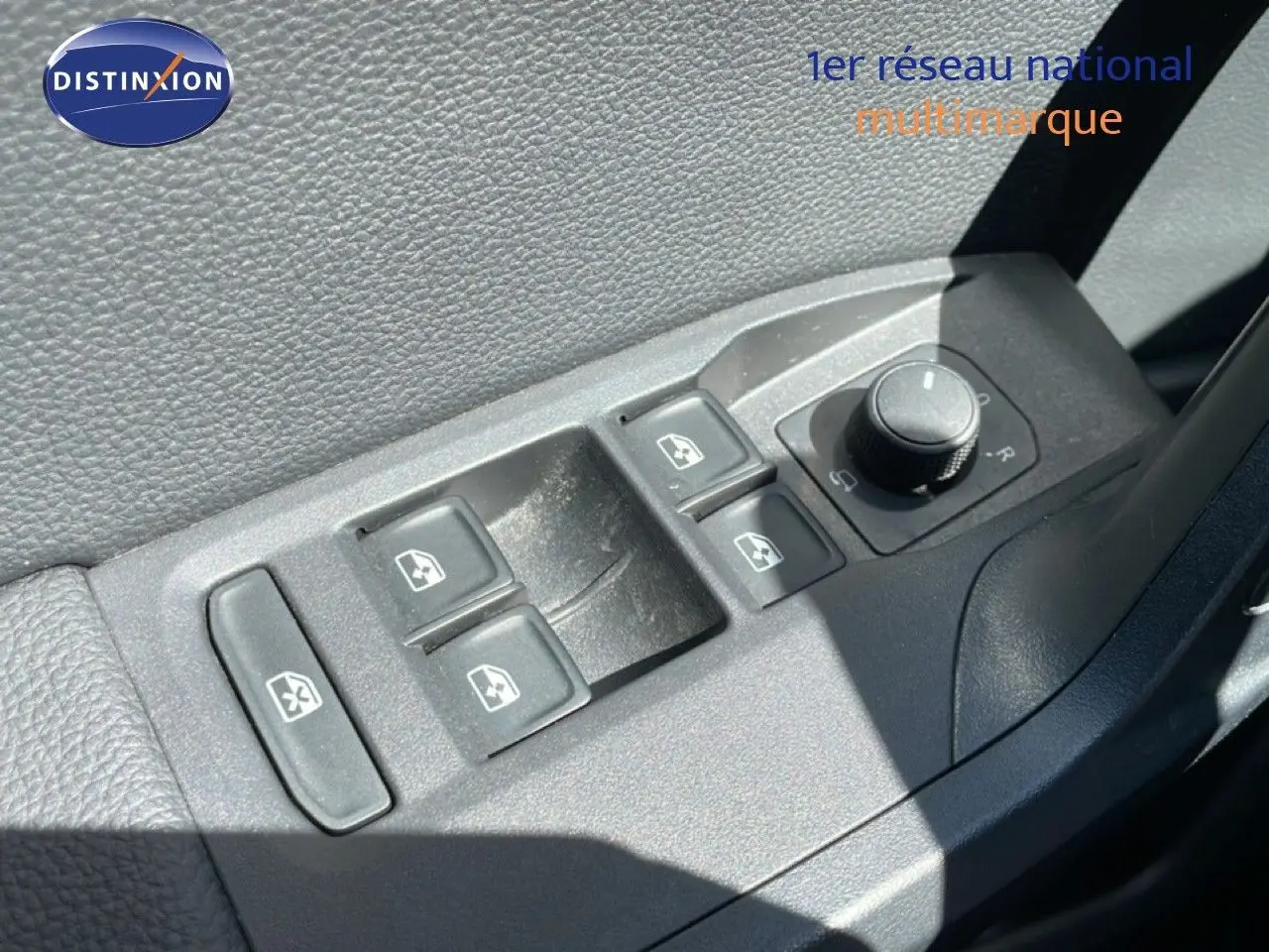 Gros plan sur les commandes électriques des vitres et rétroviseurs côté conducteur d’un SEAT Arona blanc toit noir.