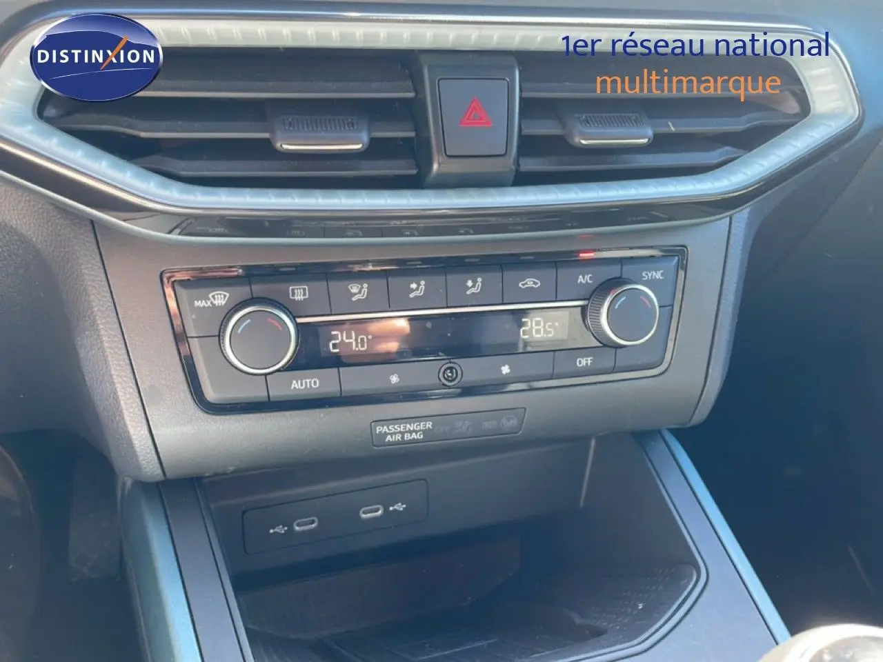Vue rapprochée de la console centrale du SEAT Arona 2025, avec commandes de climatisation digitales et prises USB visibles.