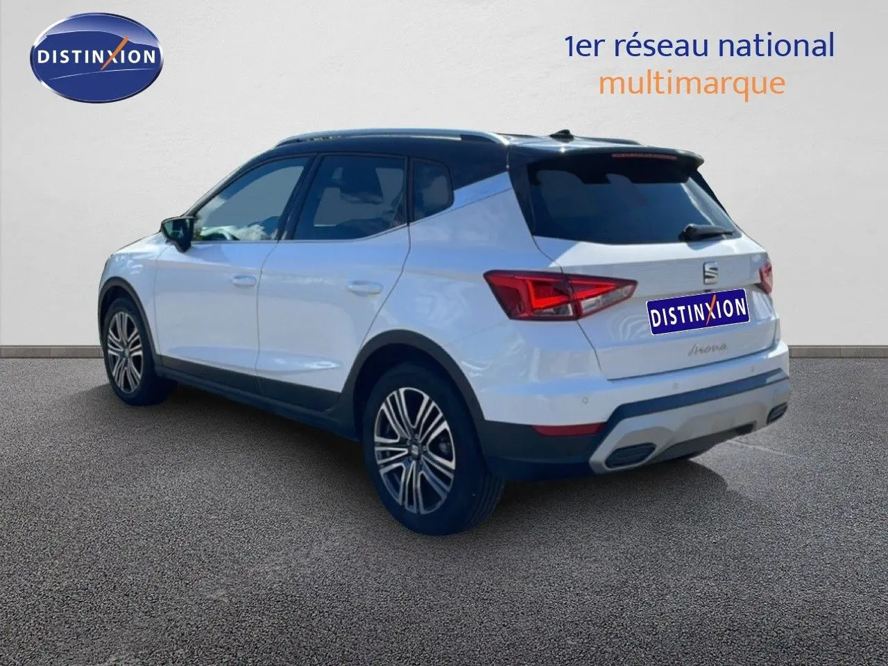 Vue 3/4 arrière droite d'un SEAT Arona blanc à toit noir avec jantes alliage et feux LED distinctifs.