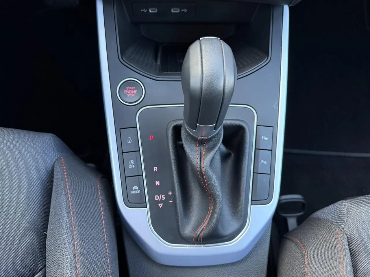 Gros plan sur la console centrale et levier de vitesse noir avec surpiqûres rouges du SEAT Arona 2024.