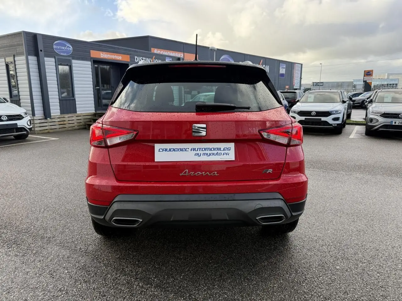 Vue arrière d'un SEAT Arona rouge 2024 avec logo FR et double sortie d'échappement intégrée au pare-chocs noir.