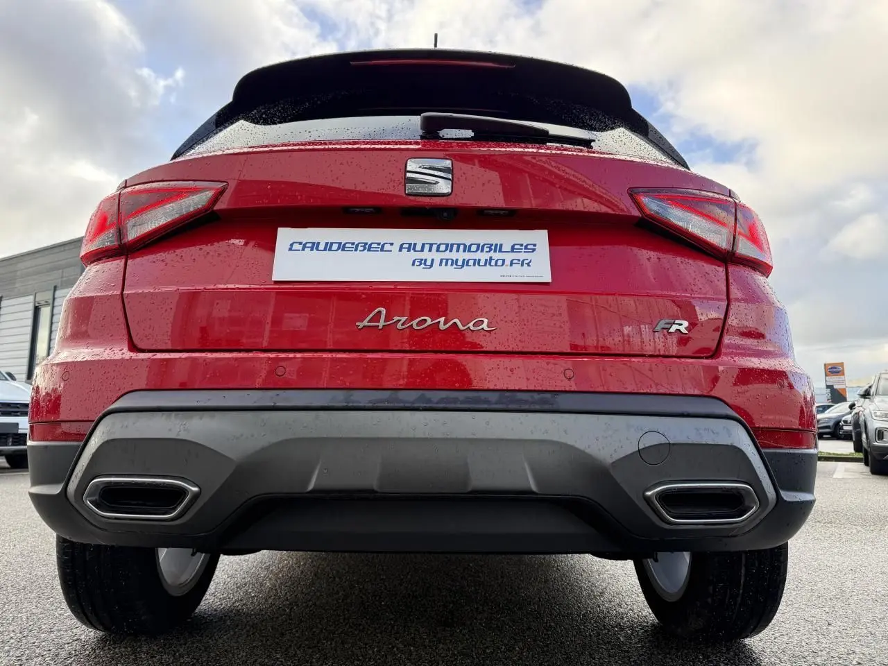 Vue arrière d'une SEAT Arona rouge 2024 avec logo FR et double sortie d'échappement intégrée au pare-chocs.