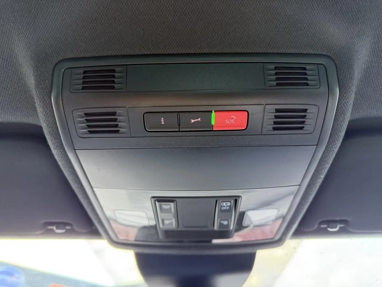 Vue en gros plan du plafonnier intérieur noir avec bouton SOS rouge et commandes d'éclairage du SEAT Arona 2024.