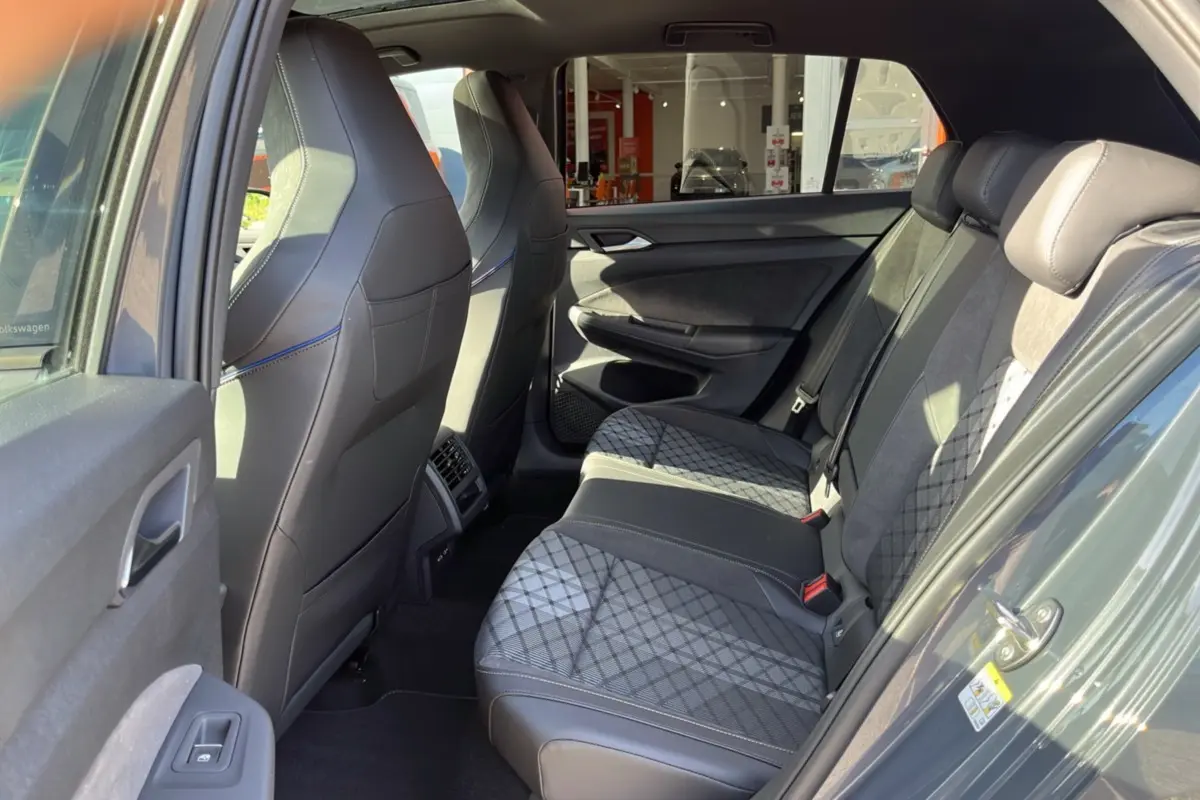 Vue intérieure arrière côté gauche de la Volkswagen Golf E-TSI 150 R-Line gris dauphin, sièges arrière en tissu et cuir avec motifs.