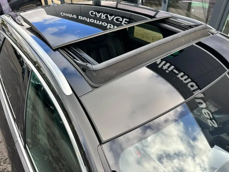 Toit ouvrant panoramique ouvert sur Audi A6 Avant noir métal vue de dessus côté gauche avec barres de toit argentées