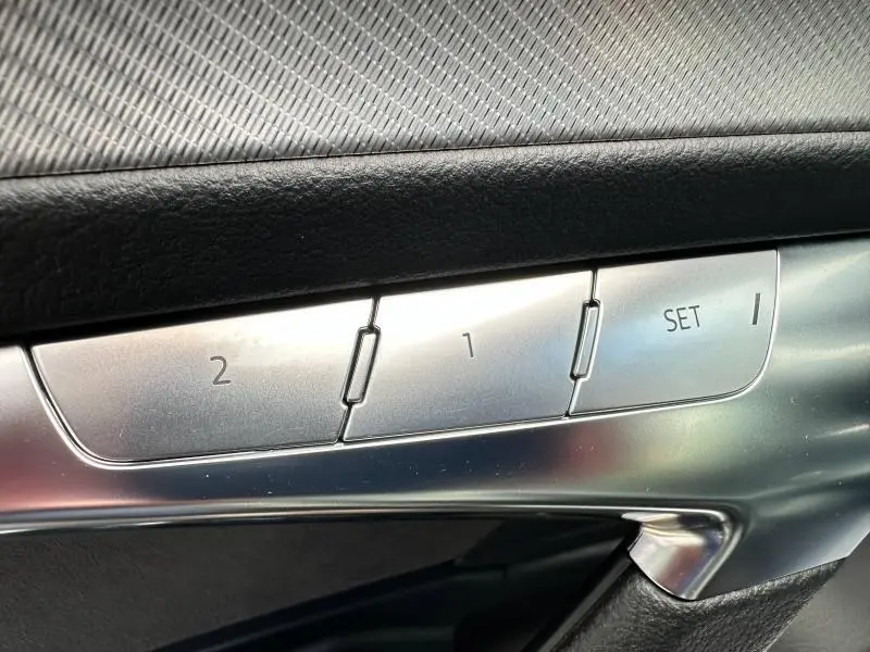 Détail des commandes de réglage mémoire des sièges en métal brossé sur la porte côté conducteur d'une Audi A6 Avant noir métal.