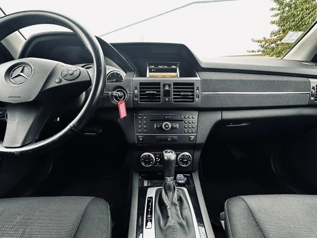 Intérieur noir de Mercedes GLK 220 CDI 2010, vue frontale sur tableau de bord et levier de boîte automatique.