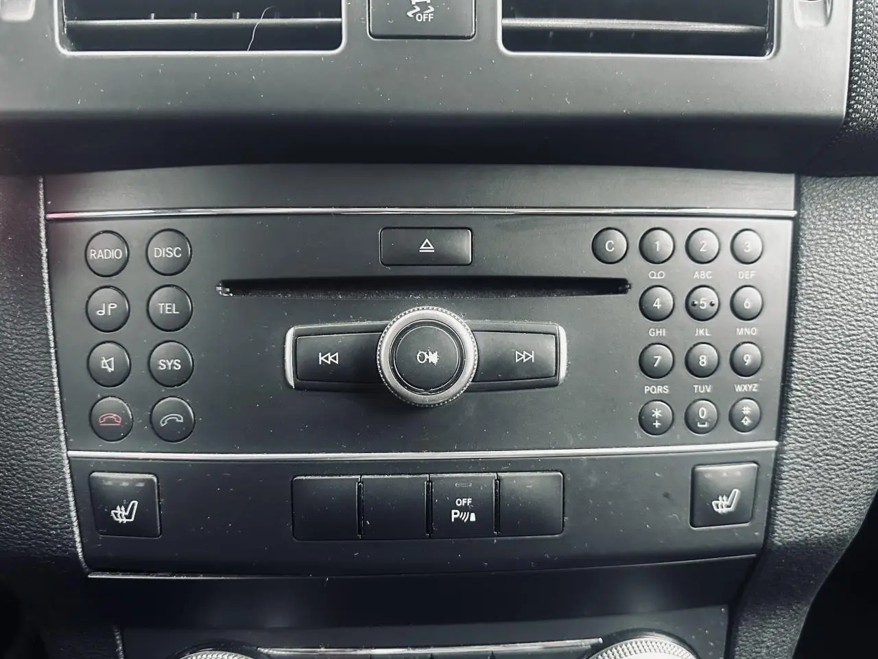 Console centrale noire du Mercedes GLK 220 CDI 4-Matic 2010 avec commandes radio, téléphone et sièges chauffants.