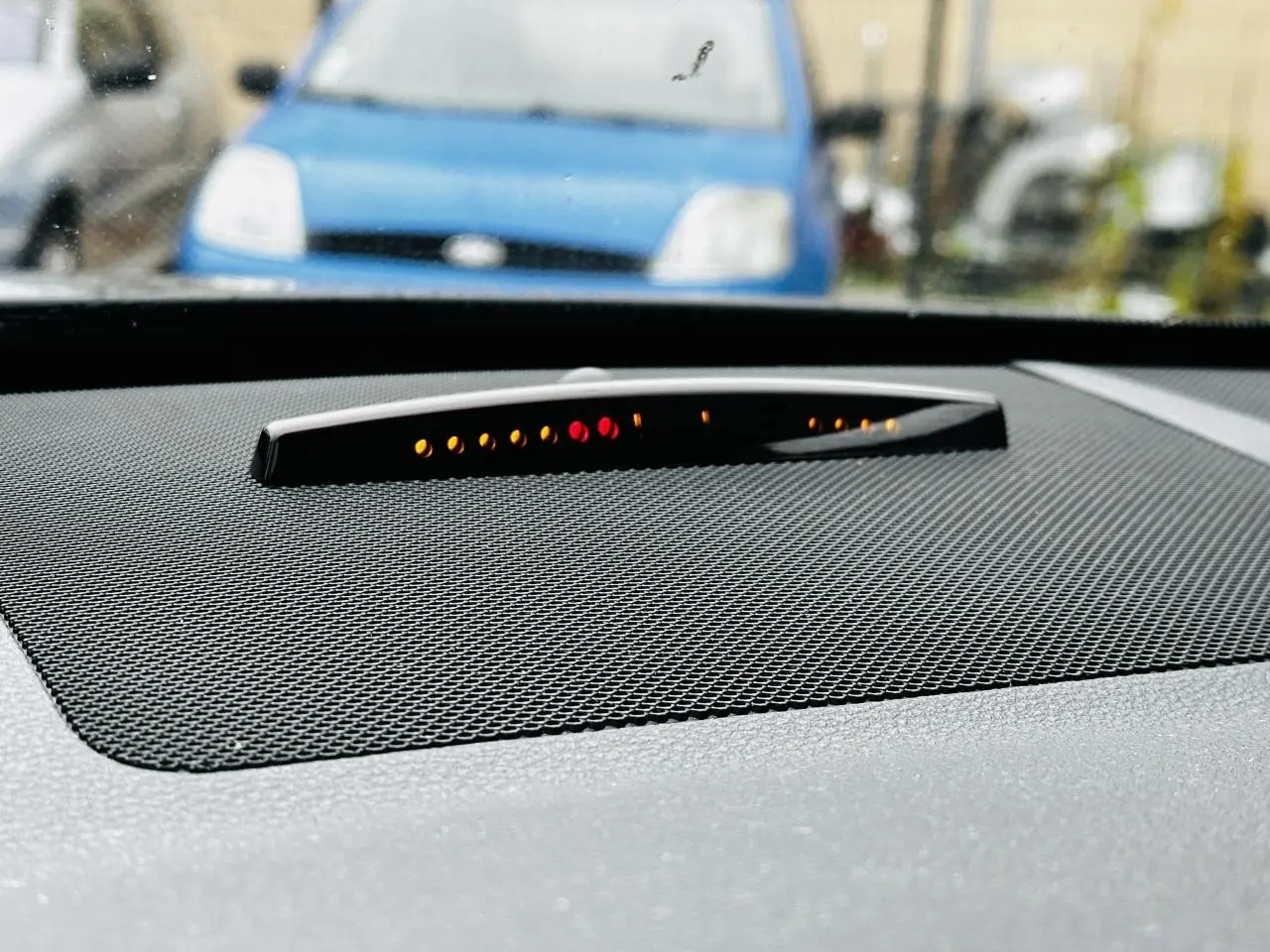 Gros plan sur le tableau de bord noir du Mercedes GLK 220 CDI 4-Matic avec indicateur de stationnement lumineux intégré.