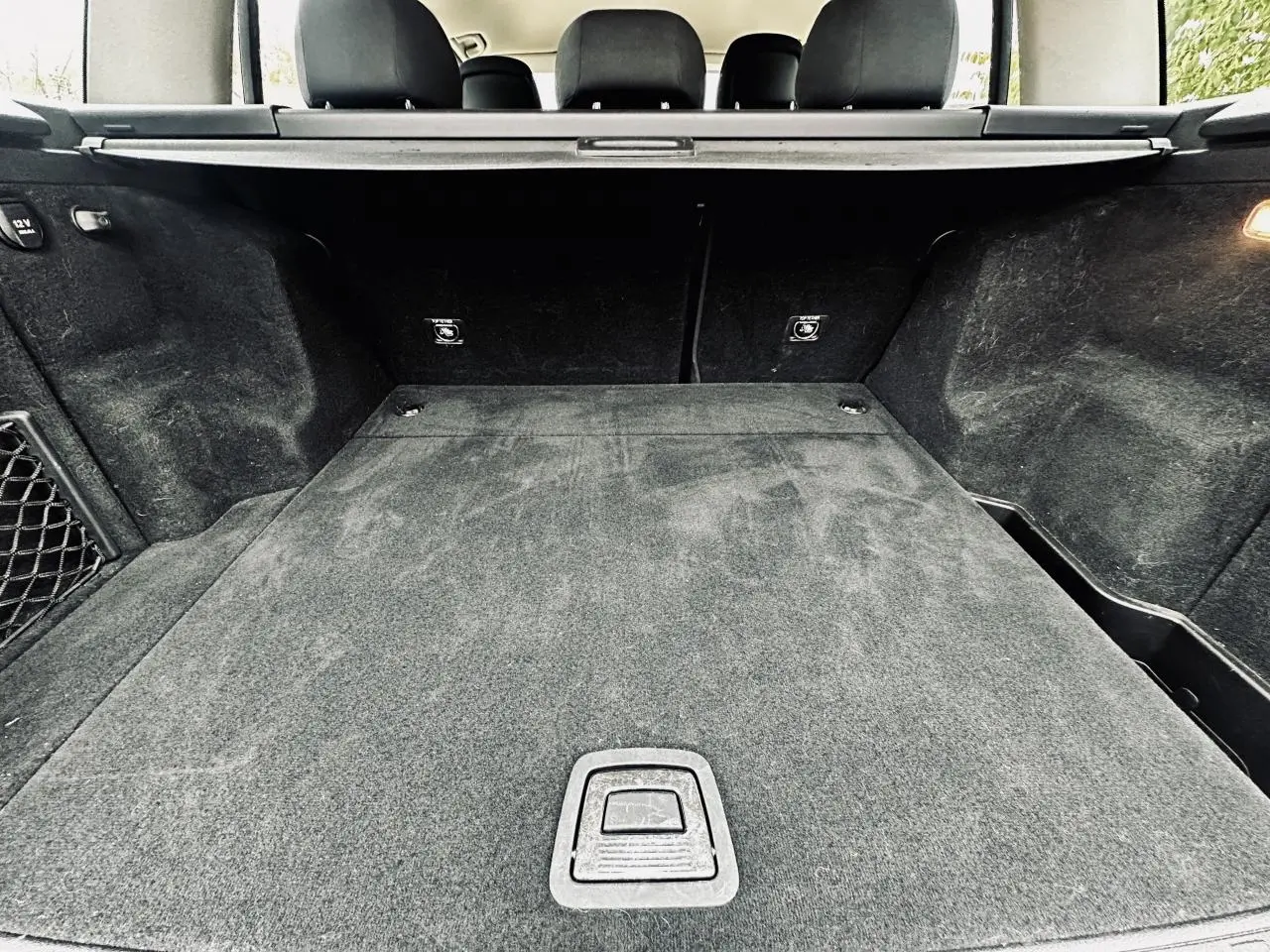 Coffre noir spacieux de Mercedes GLK 220 CDI 4-Matic vu de l'arrière avec cache-bagages et sièges rabattus.