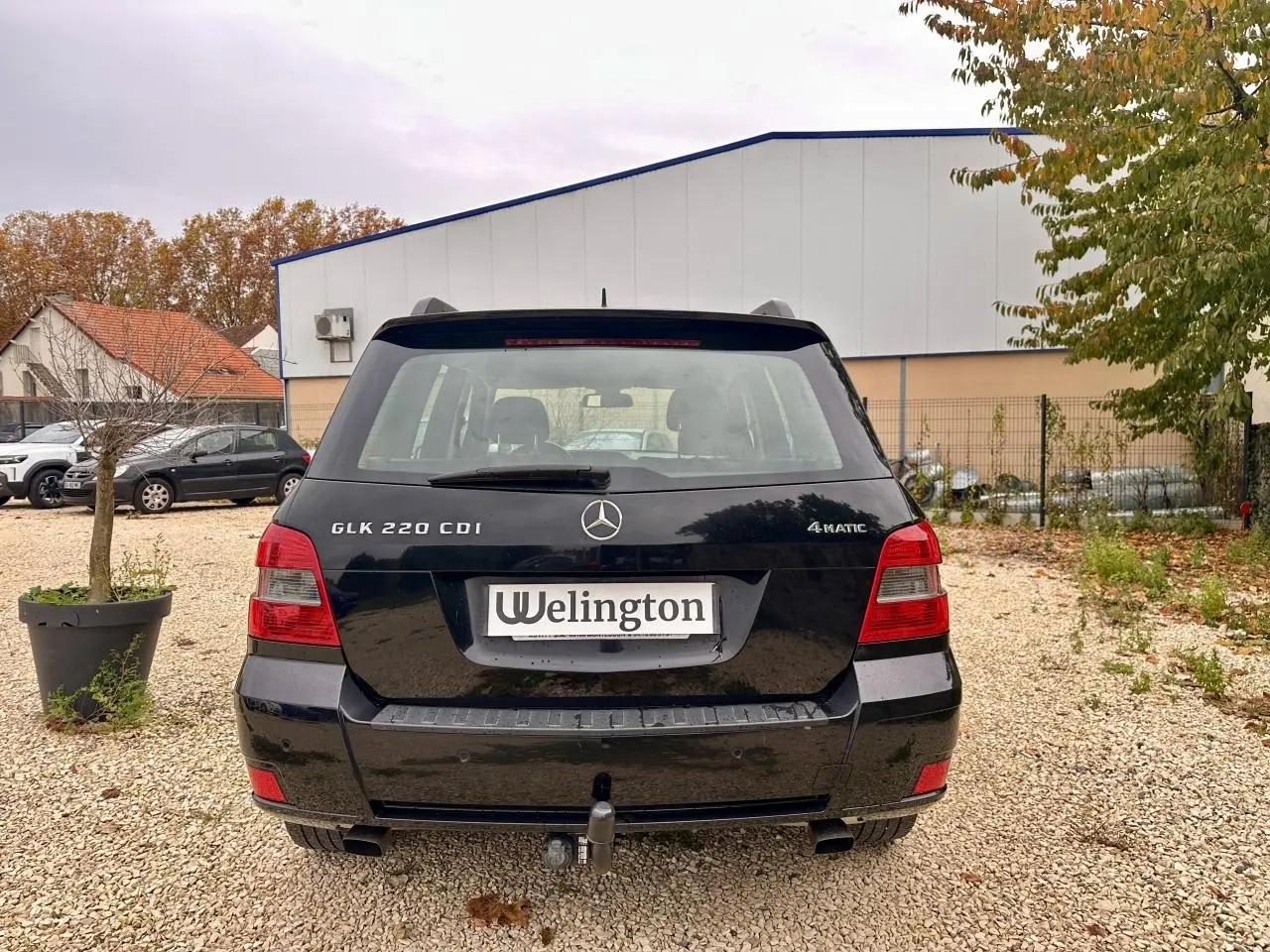 Vue arrière d'un Mercedes GLK 220 CDI noir avec badge 4MATIC et attelage de remorque visible.