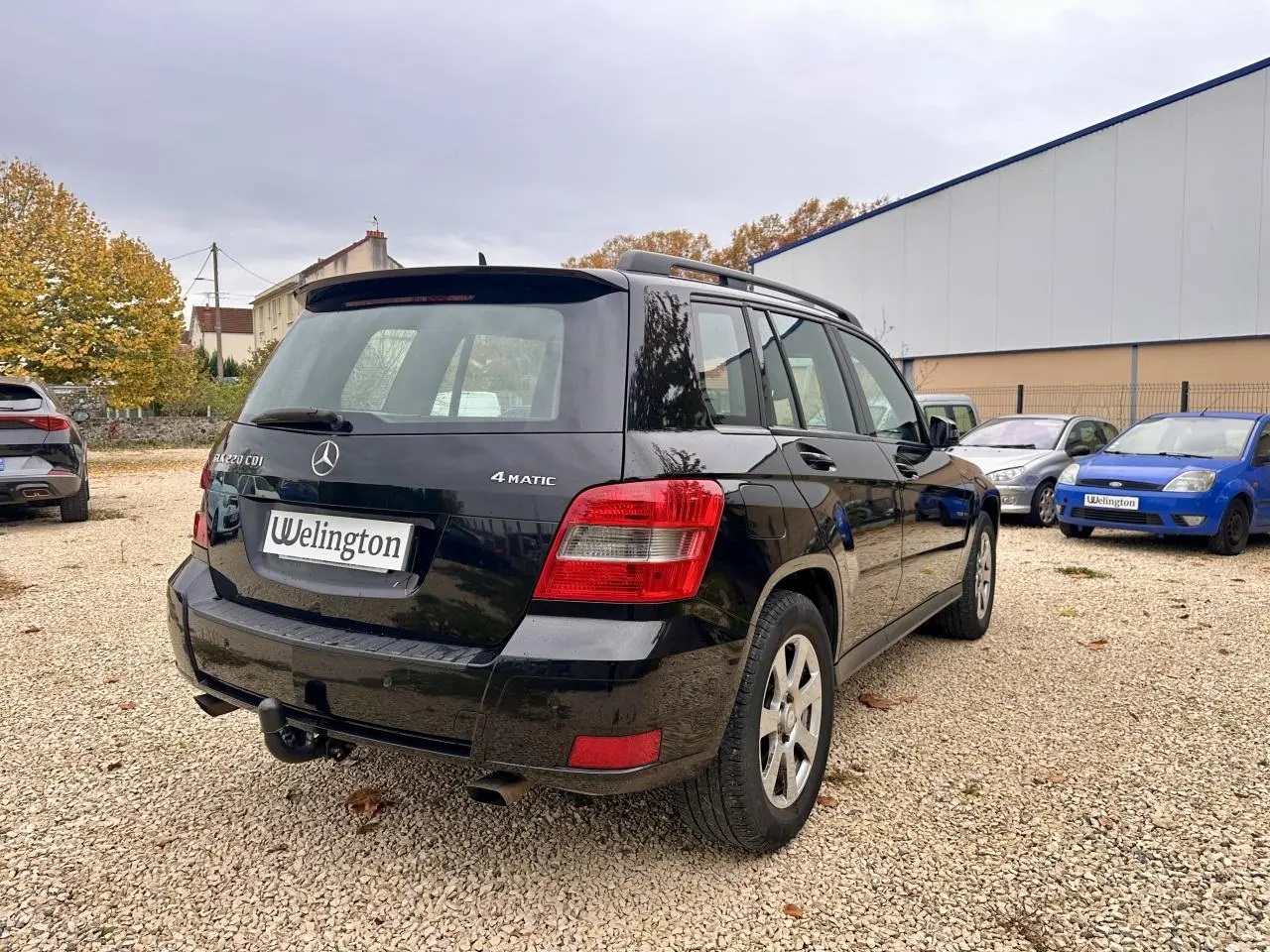Vue 3/4 arrière droite d'un Mercedes GLK 220 CDI noir avec attelage et logo 4MATIC visible.