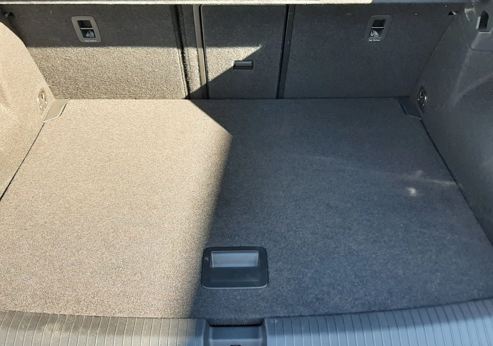 Vue intérieure du coffre spacieux et gris du Volkswagen T-Roc 2.0 TDI 150CH R-LINE DSG7 2024, avec revêtement tissu.