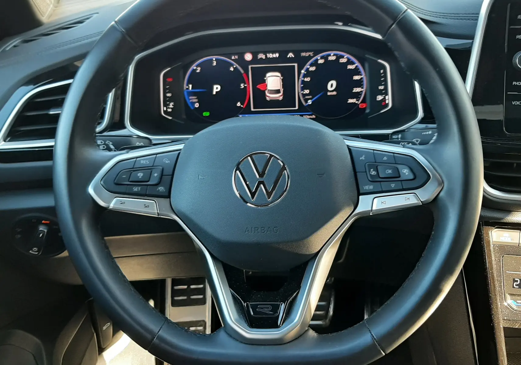 Vue frontale du volant noir du Volkswagen T-Roc 2.0 TDI 150CH R-LINE 2024 avec tableau de bord numérique allumé.
