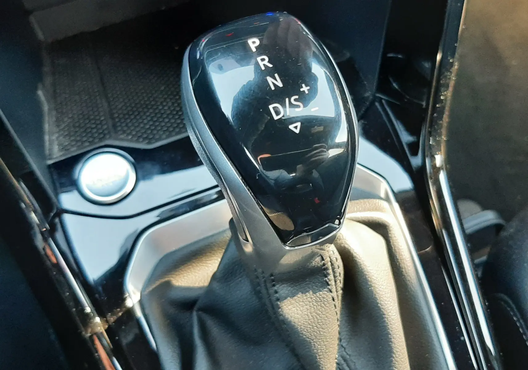 Le levier de vitesses automatique noir brillant du Volkswagen T-Roc 2024, vue rapprochée de l’intérieur.