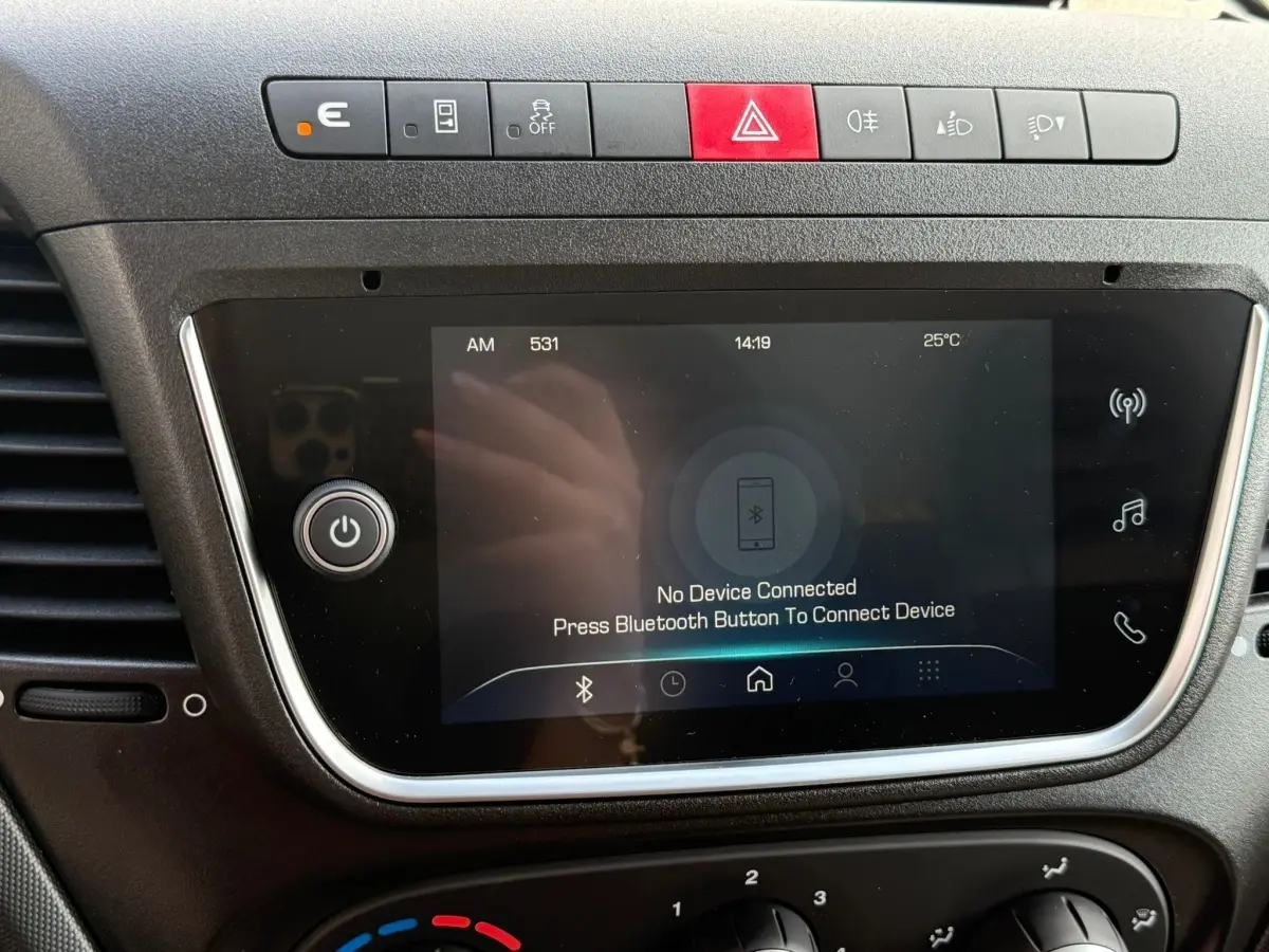 Écran tactile central du tableau de bord du fourgon Iveco Daily blanc 2026 avec commandes de sécurité et connectivité Bluetooth.